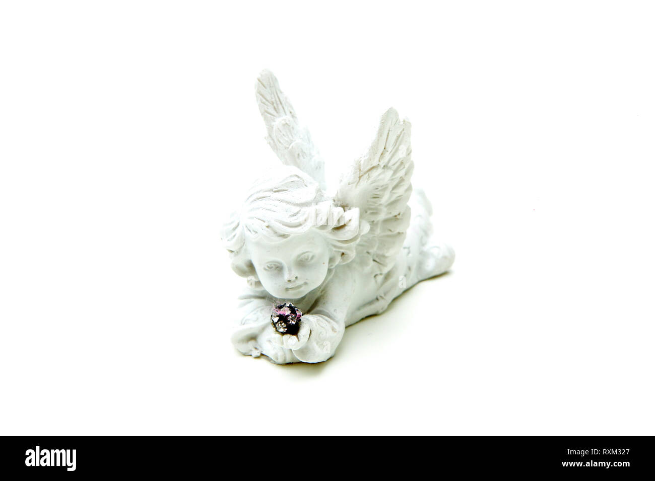 Une petite sculpture décorative d'un ange enfant tenant quelques petites pierres brillantes dans une forme sphérique. Banque D'Images