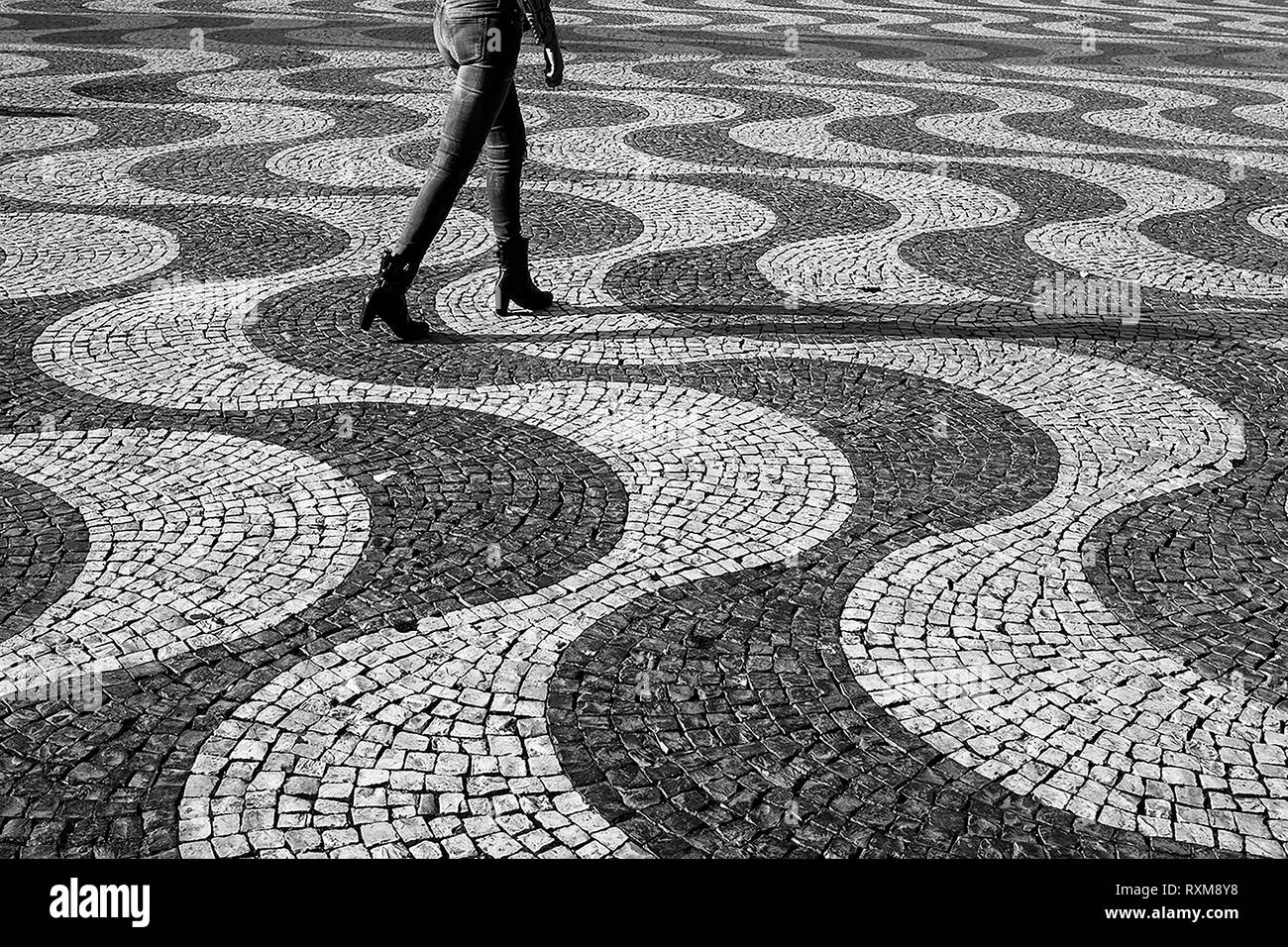 Les jambes d'une femme marche à travers la célèbre vague, pavés, Rossio, Lisbonne, Portugal, version noir et blanc Banque D'Images