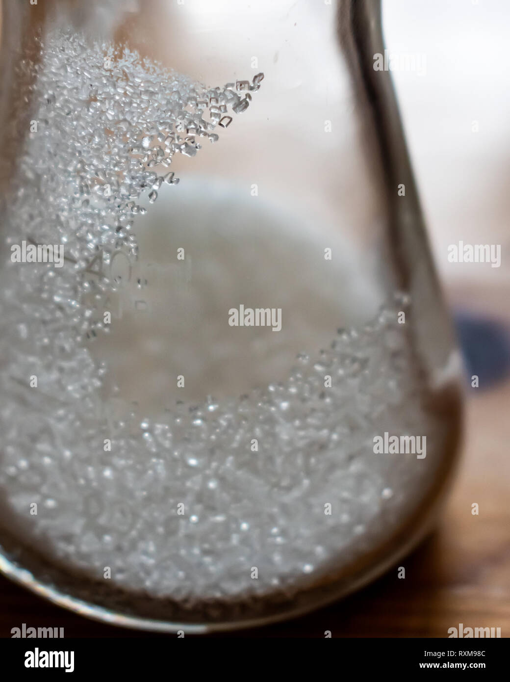 Erlenmeyer contenant des cristaux de sucre de table à l'intérieur. Certains cristaux s'accrocher aux parois de la fiole avec certains même étant nettement visible et unique Banque D'Images