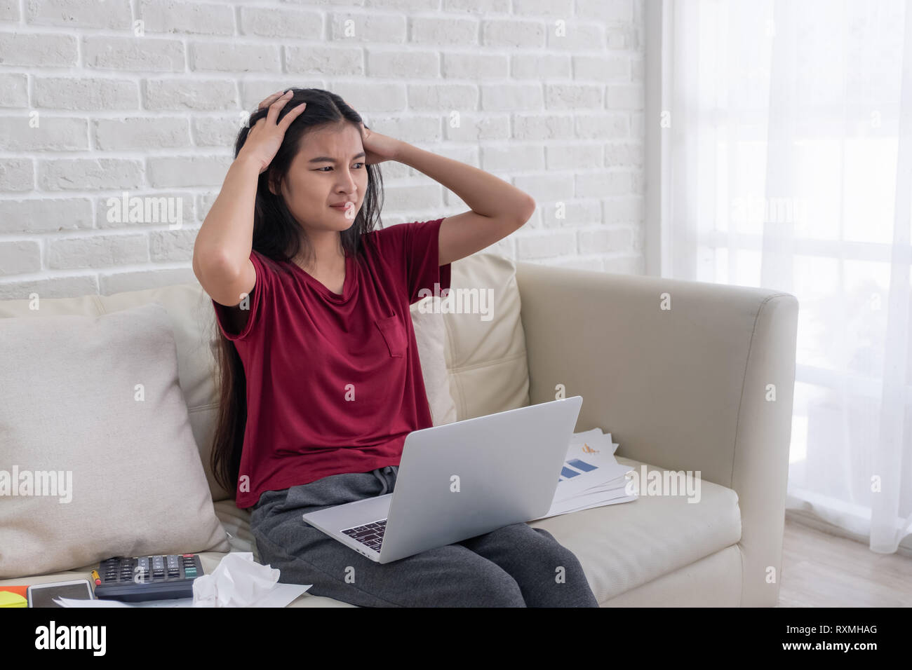 Asian woman freelancer souligner l'émotion tout en travaillant avec un ordinateur portable et des formalités administratives de canapé dans la salle de séjour en chambre.travailler à domicile concept. Banque D'Images