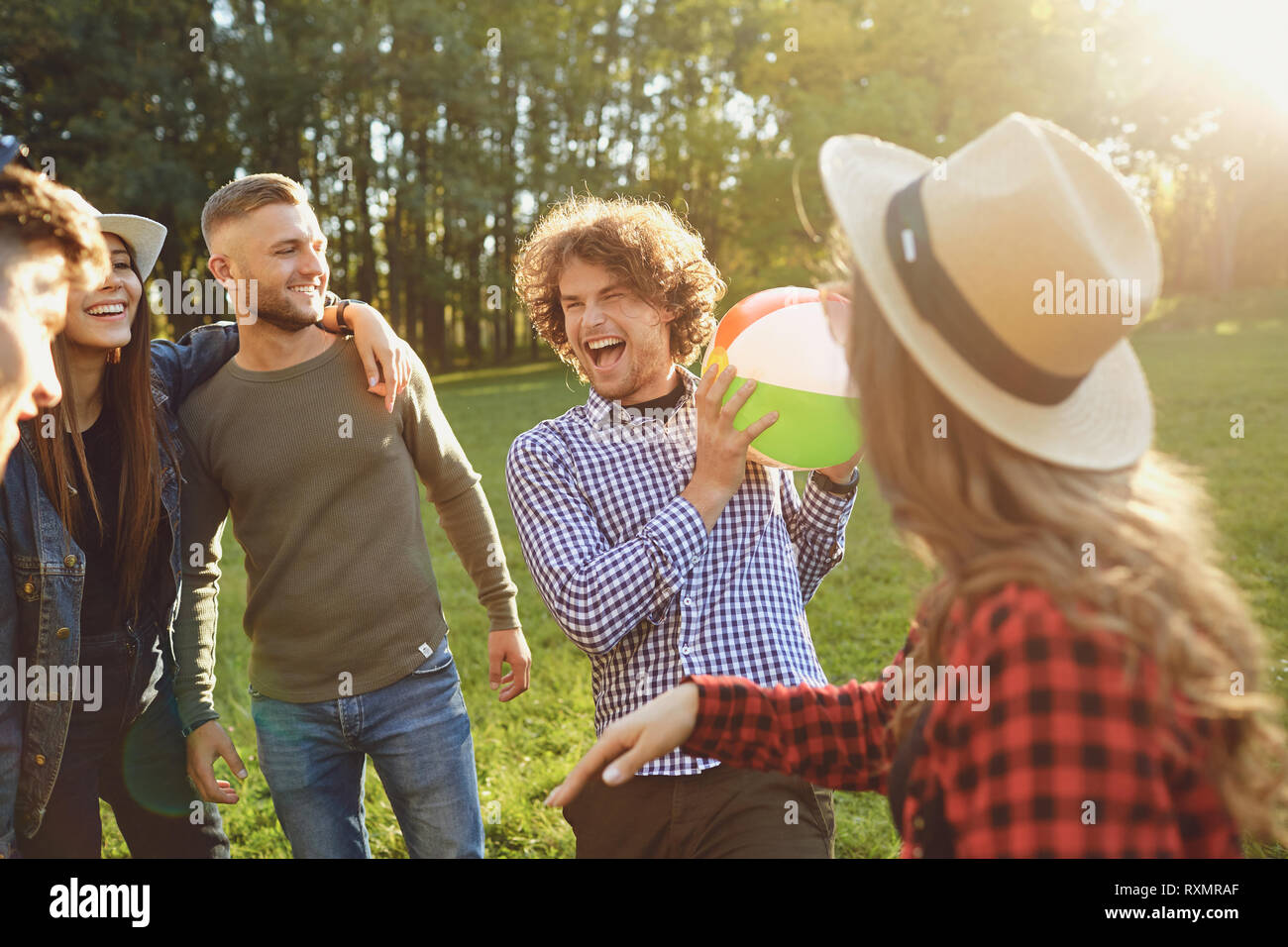 Les amis jouer dans le parc avec la balle dans l'été. Banque D'Images