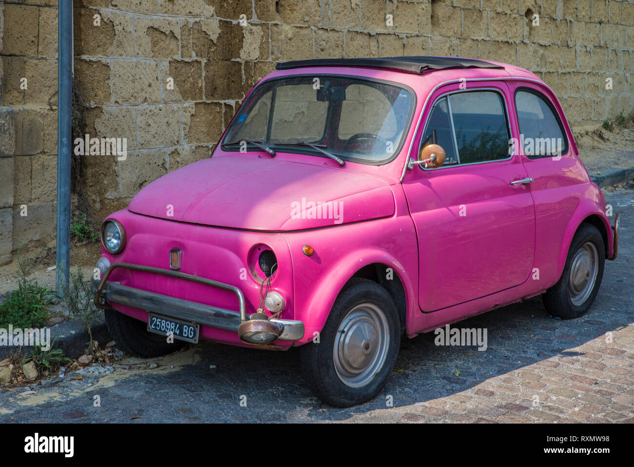 Naples, Italie - 14 août 2015 : Oldtimer voiture Fiat Nuova 500 Rose se tient dans les rues de Naples. Ses phares sont cassés. Banque D'Images