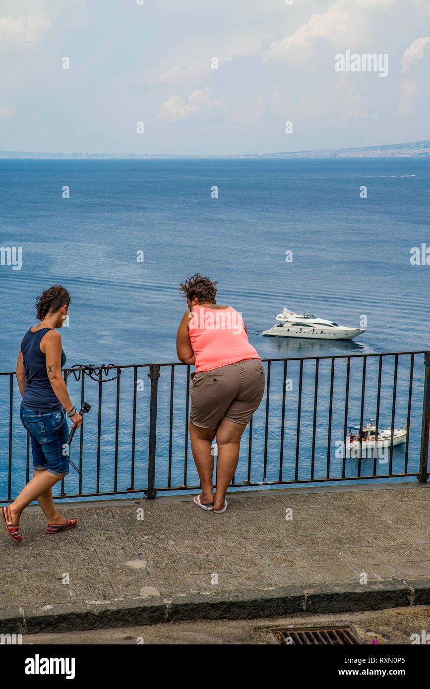 Naples, Sorrento Italie - le 10 août 2015 : une vue du haut de la plage de Sorrente. Une femme rondelette se tourne vers la mer et les bateaux. Banque D'Images