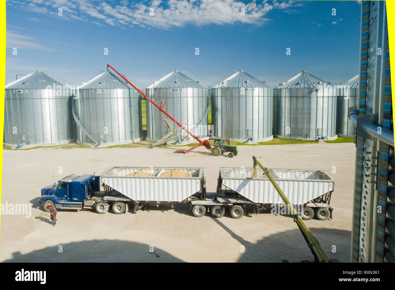 Un super B camion de grain en cours de chargement avec l'orge des bacs de stockage de grain, près de Saint Jean, Manitoba, Canada Banque D'Images