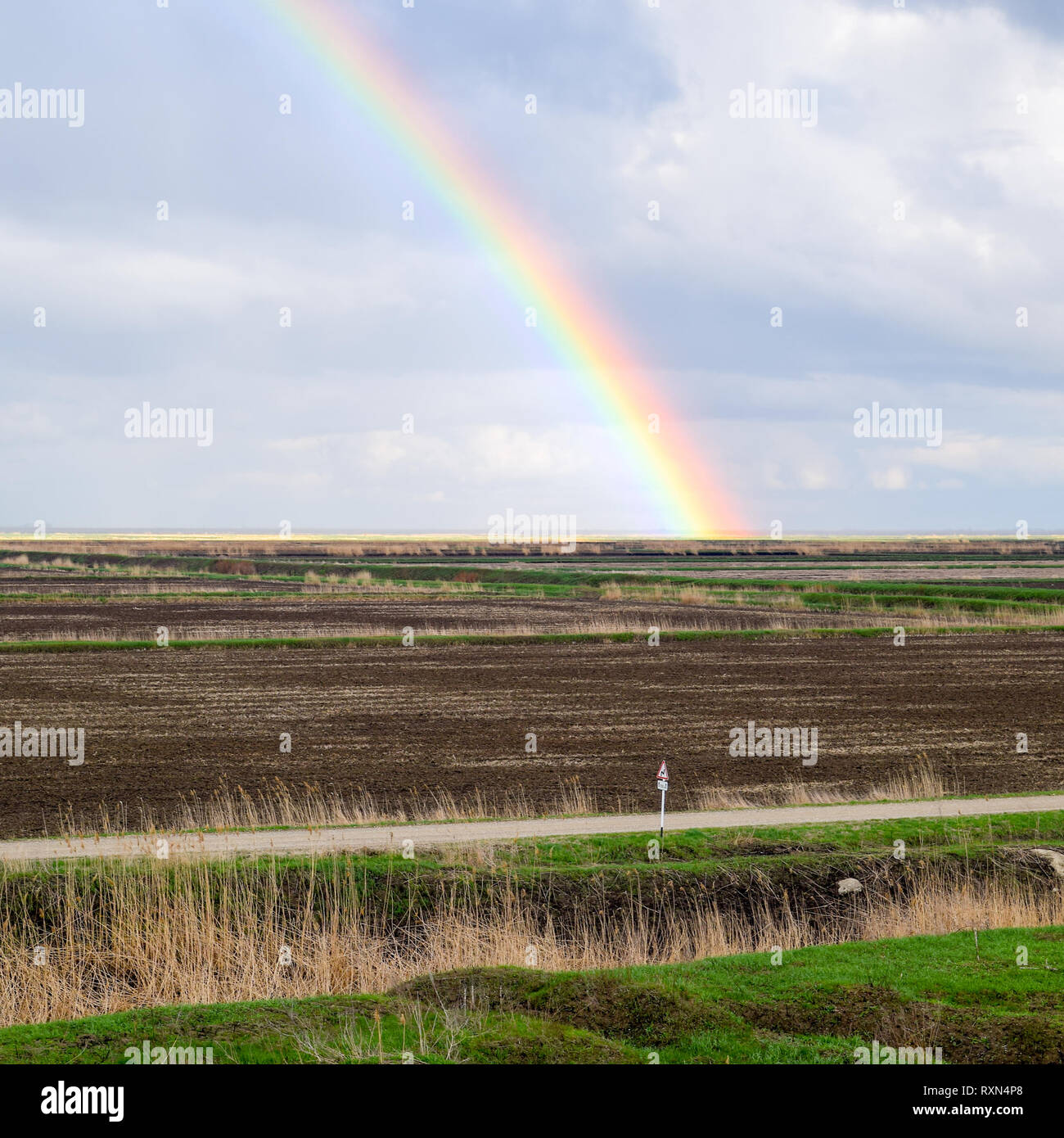 Arc-en-ciel, une vue sur le paysage dans le domaine. Formation de l'arc en ciel après la pluie. La réfraction de la lumière et de l'expansion en termes de spectres. Banque D'Images