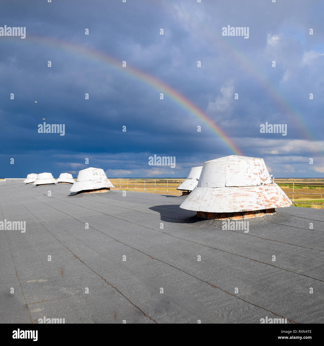 Arc-en-ciel, vue depuis le toit de l'immeuble. Les sorties de ventilation sur le toit de l'édifice. Banque D'Images