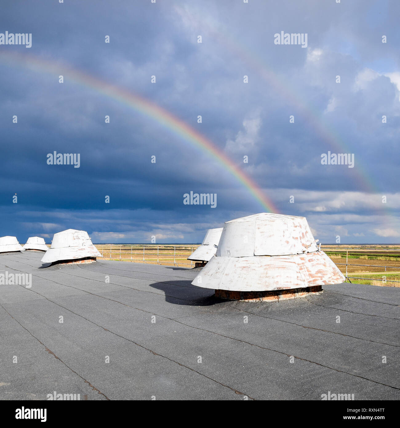 Arc-en-ciel, vue depuis le toit de l'immeuble. Les sorties de ventilation sur le toit de l'édifice. Banque D'Images
