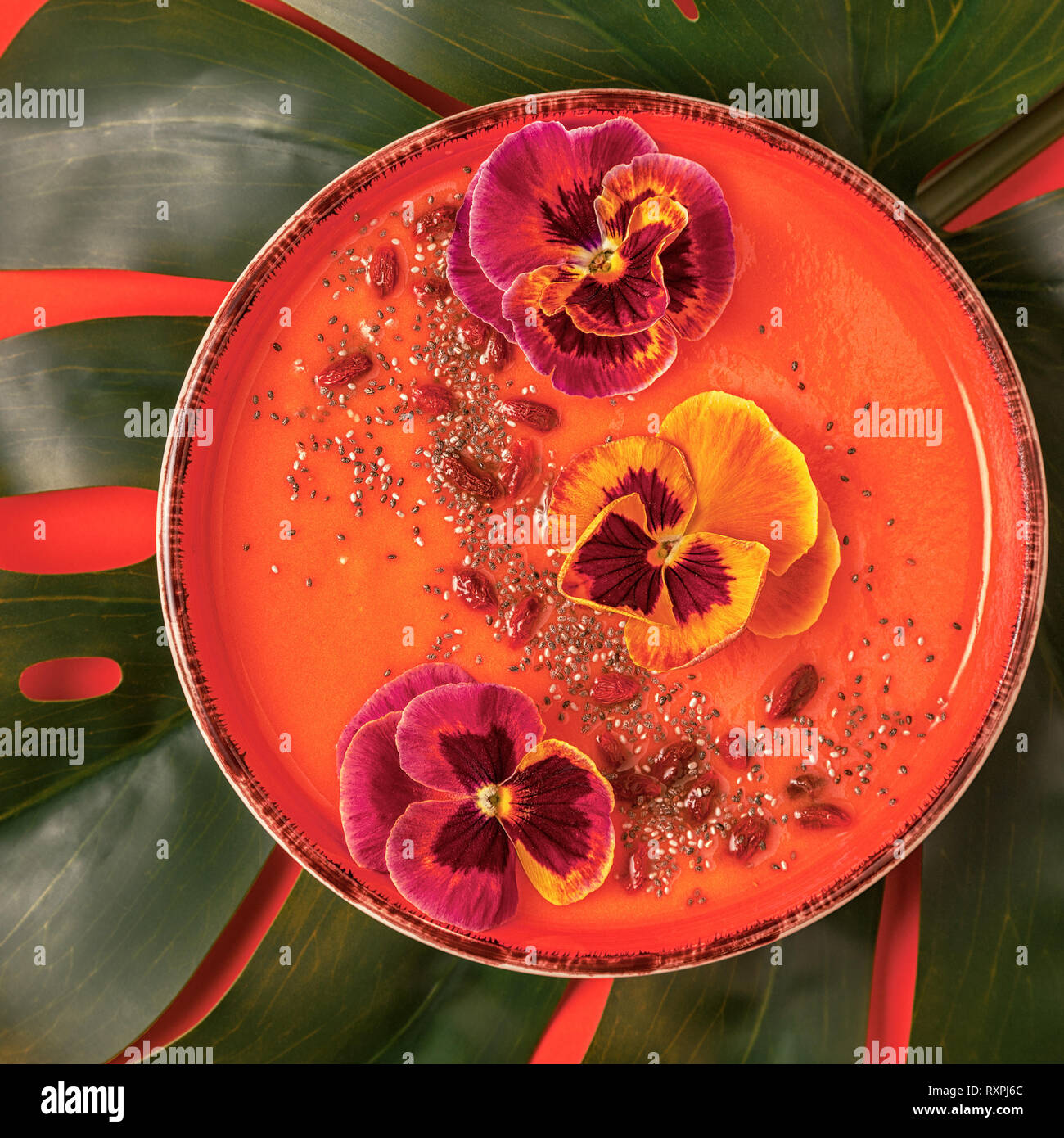 Bol à smoothie fleur comestible, graines de chia, les baies de goji, vue du dessus. Banque D'Images