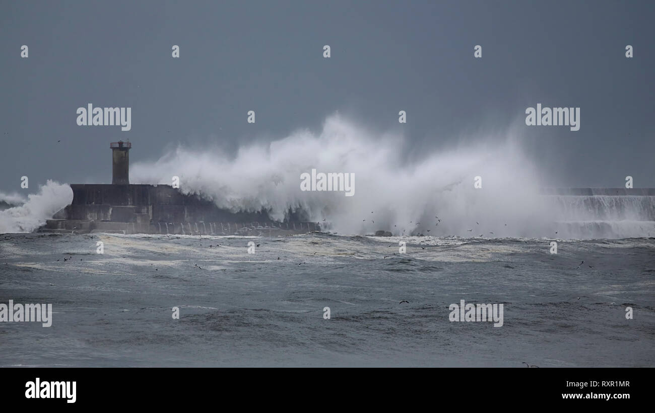 La jetée sud du port de Leixoes couverts par de grandes vagues de la mer, au cours de la tempête du nord du Portugal. Banque D'Images