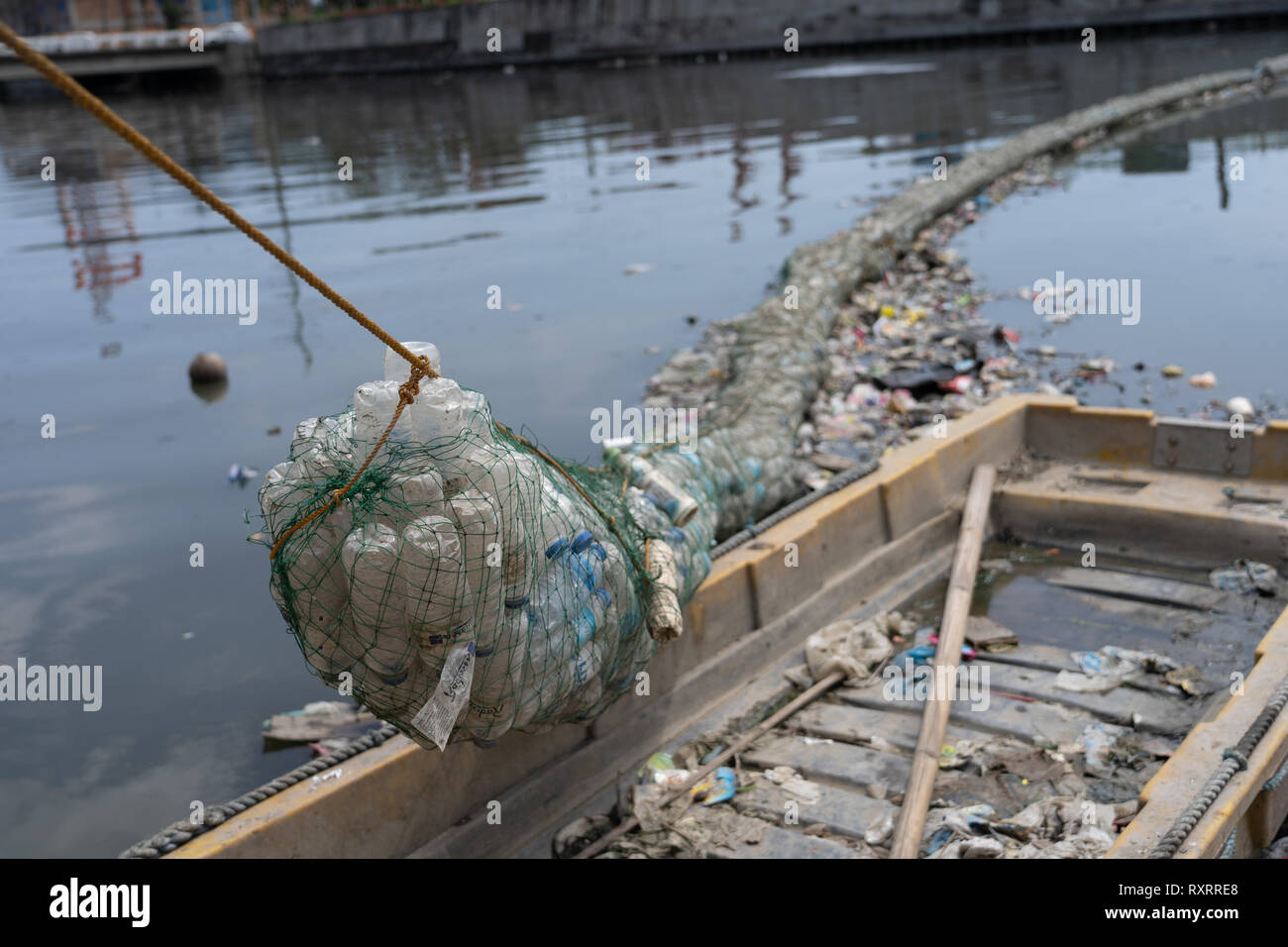 La ville de Cebu, aux Philippines. 10 Mar 2019. Une barrière faite de bouteilles de plastique recyclées encastrés dans compensation apparaissent sur une rivière utilisée pour capturer les déchets qui seraient autrement flotter vers le bas dans l'océan.Un rapport récent par l'ONG ( GAIA) (Alliance mondiale pour l'Incinérateur Alternatives) met en évidence l'utilisation de choquant dans une seringue de plastique dans les Philippines.Les chiffres comprennent quelque 60 milliards de sachets à usage unique, 57 millions de sacs à environ 16,5 milliards de petits sacs en plastique appelé "Labo" soit utilisée chaque année. Credit : gallerie2/Alamy Live News Banque D'Images