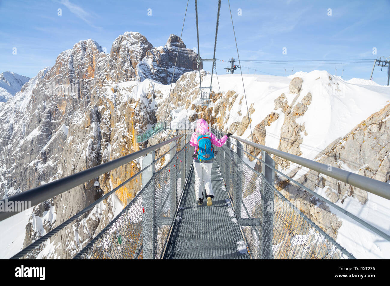 Femme marchant sur le pont de corde sur la montagne Dachstein Banque D'Images