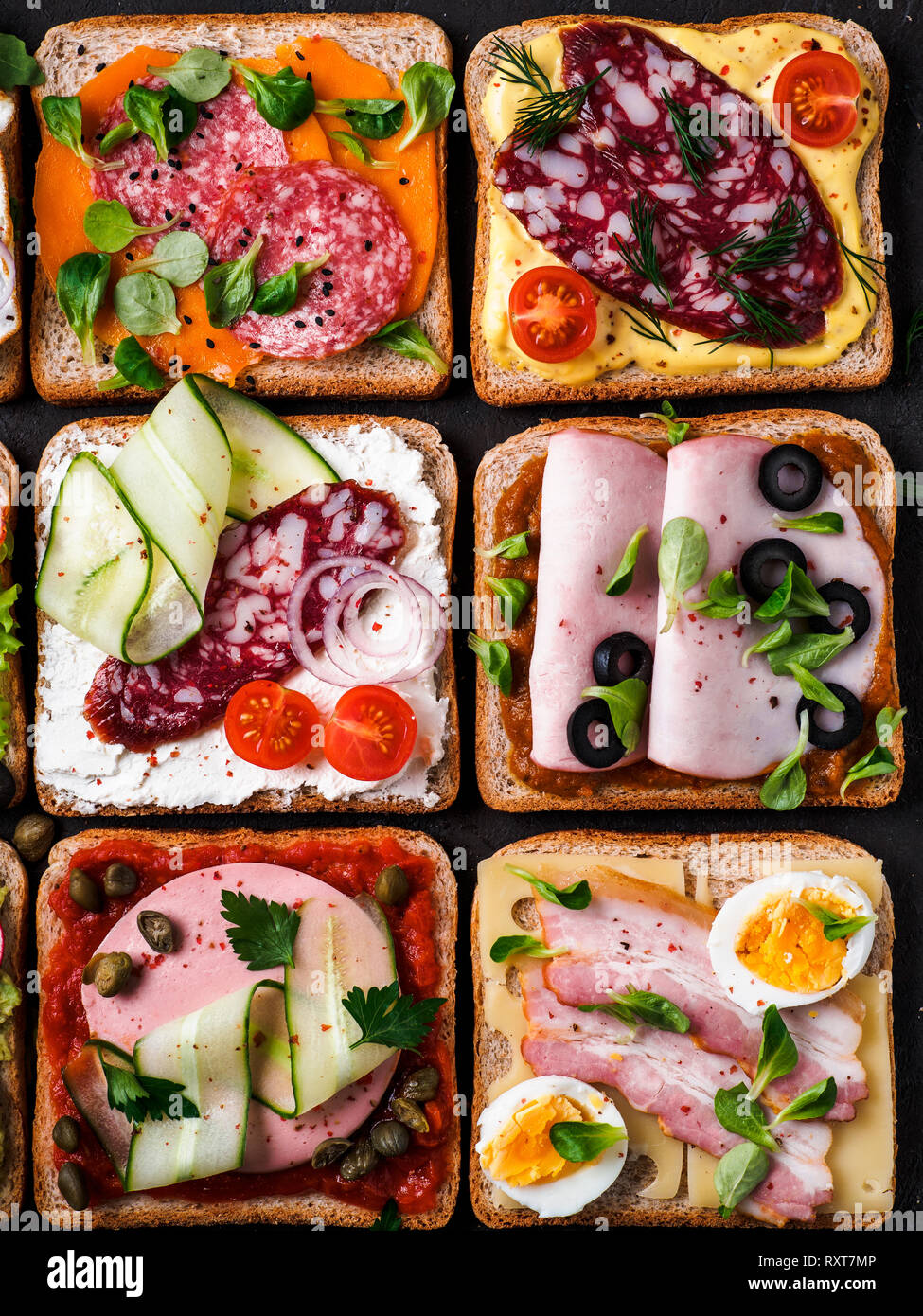Ensemble de huit différents sandwiches avec de la viande en forme carrée. Vue de dessus ou de télévision. Toasts viande assortiment sur fond noir. Idée, concept créatif pour charcutier Banque D'Images