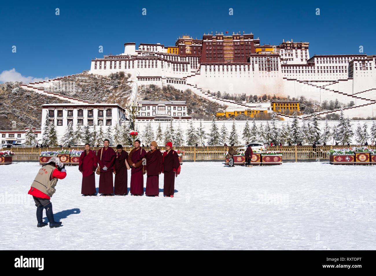 Lhasa, Chine - 19 décembre 2018 : Le bouddhisme tibétain moines posant pour la photo devant le Palais du Potala sur une journée d'hiver ensoleillée au Tibet. Banque D'Images