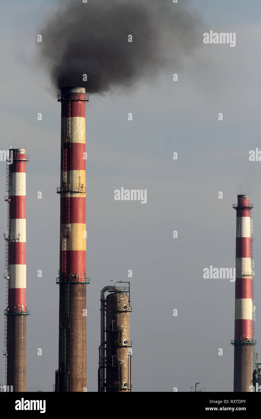 Rouge et blanc sale cheminée en béton d'une raffinerie de pétrole de fumée Banque D'Images