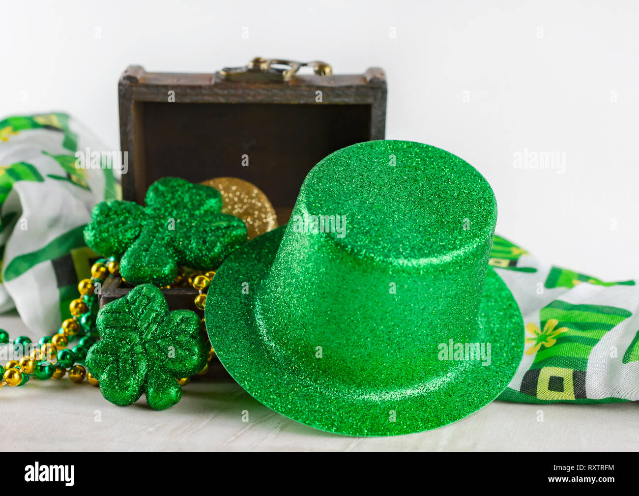 Saint Patrick's Day coffre au trésor rempli de pièces de monnaie et des  perles. Vue rapprochée de green top hat appuyé contre la poitrine. Foulard  coloré en arrière-plan Photo Stock - Alamy