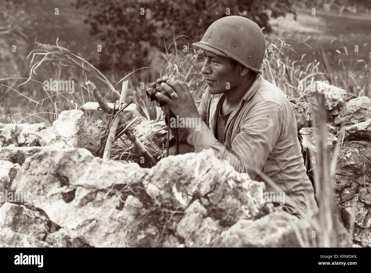 Code indiens Navajo-talker Carl Pfc Gorman de Chinle, Arizona, manning un poste d'observation sur une colline surplombant la ville de Garapan, tandis que les Marines des États-Unis ont consolidé leurs positions sur l'île de Saipan, Marianas le 27 juin 1944 lors de la bataille de Saipan. Banque D'Images