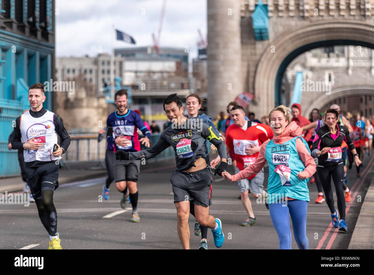 Ellie Hale s'exécutant dans la vitalité demi demi marathon traversant le Tower Bridge, Londres, Royaume-Uni. Le vent souffle fort porteur Banque D'Images