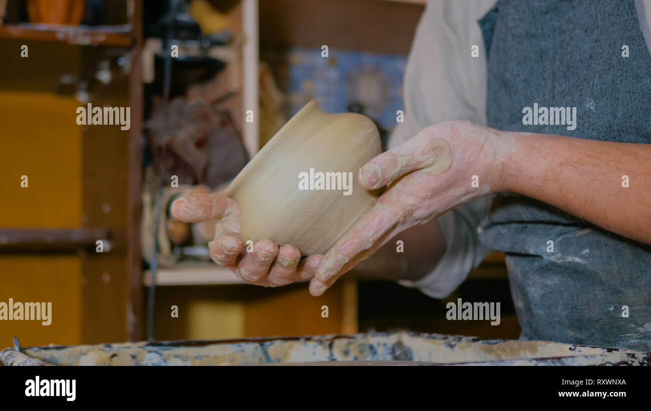 Professionnel hommes potter examinant pot dans atelier de poterie Banque D'Images