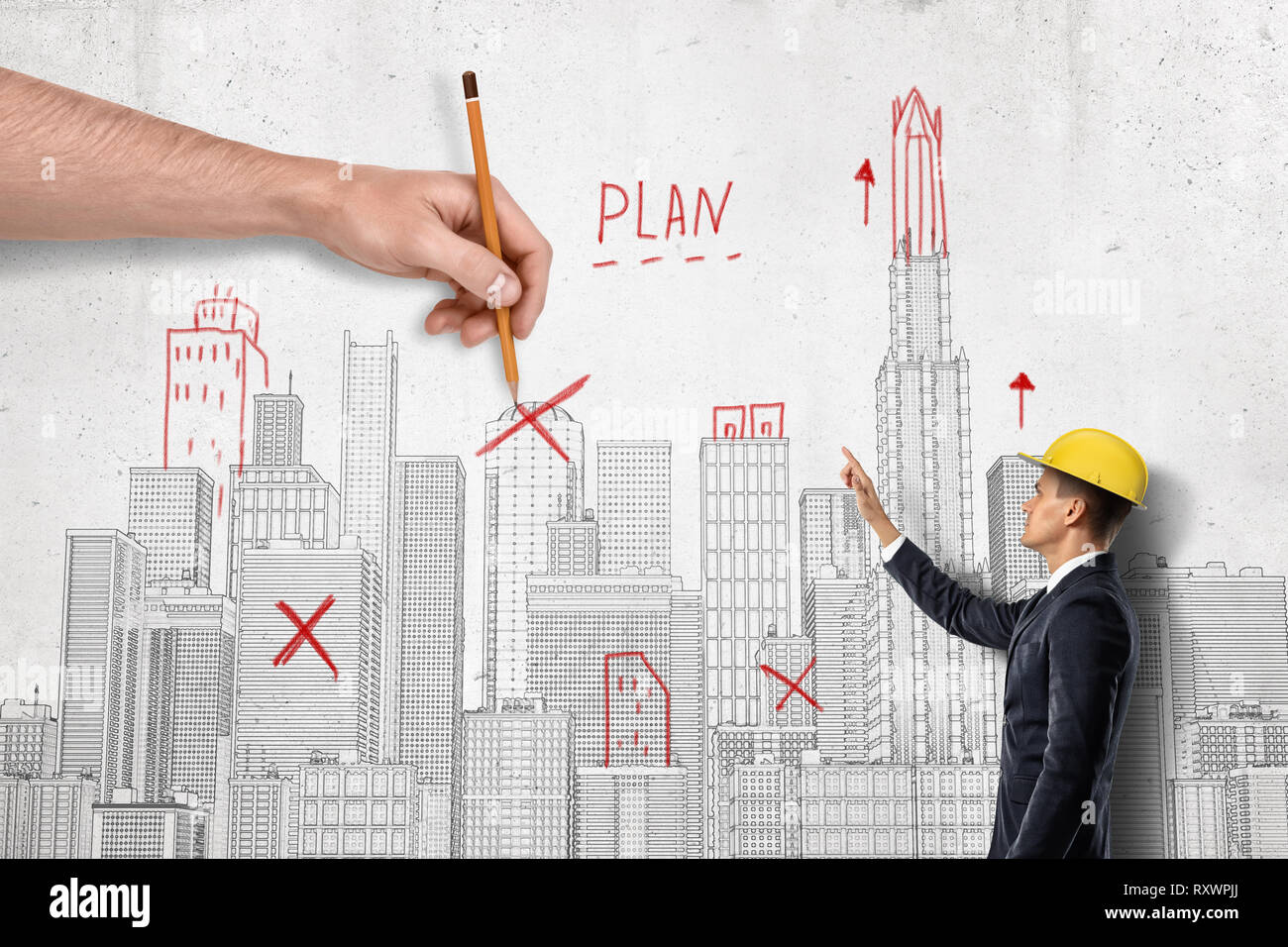 Vue latérale du businessman in hard hat à côté de mur avec plan de la ville sur elle et de grands hommes, part de l'autre côté crossing out quelques repères au crayon. Banque D'Images