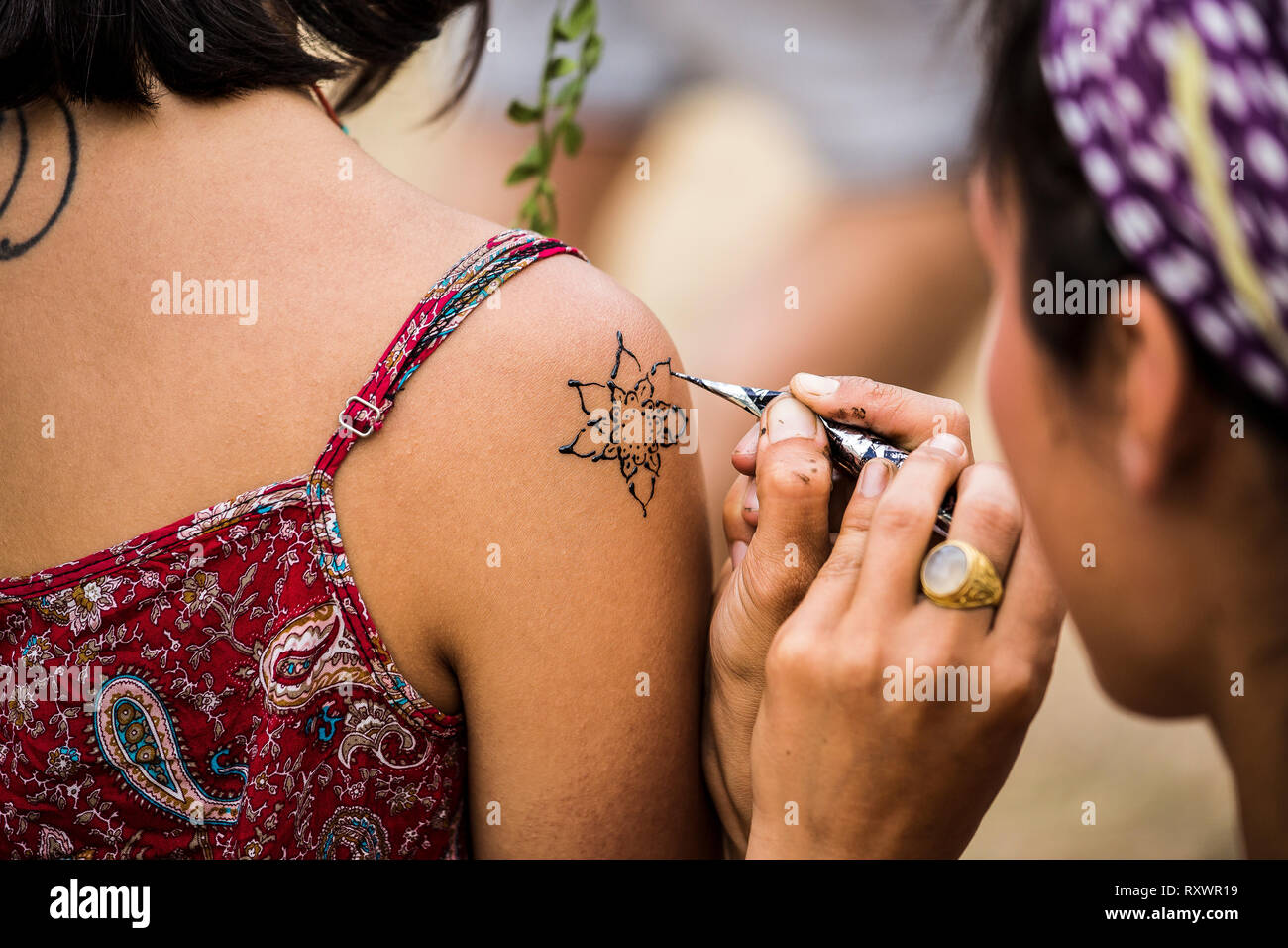 Girl painting tatouage au henné sur l'épaule dans la nature festival, Kent, UK Banque D'Images