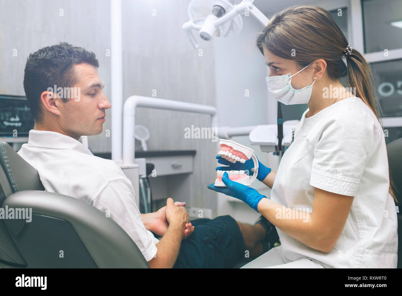 Portrait d'une femme dentiste et les jeunes professionnels patient de sexe masculin dans un bureau de dentiste. Man Banque D'Images