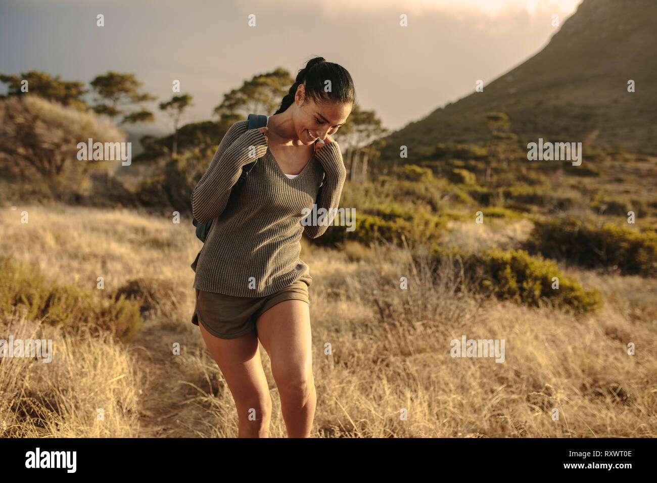 Happy woman walking down the country trail. Les jeunes femmes bénéficiant de la randonnée dans la nature. Banque D'Images