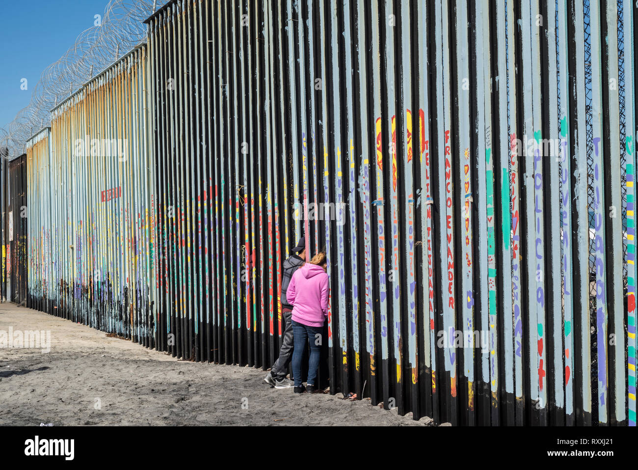 Les gens qui essaient de communiquer avec leur famille de l'autre côté de la frontière, à Tijuana, au Mexique. Banque D'Images