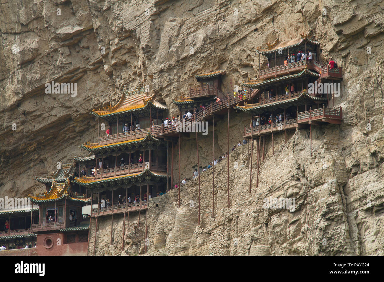 Les touristes de monter les différents niveaux de la falaise Xuankong Temple suspendu dans la province du Shanxi en Chine. Banque D'Images