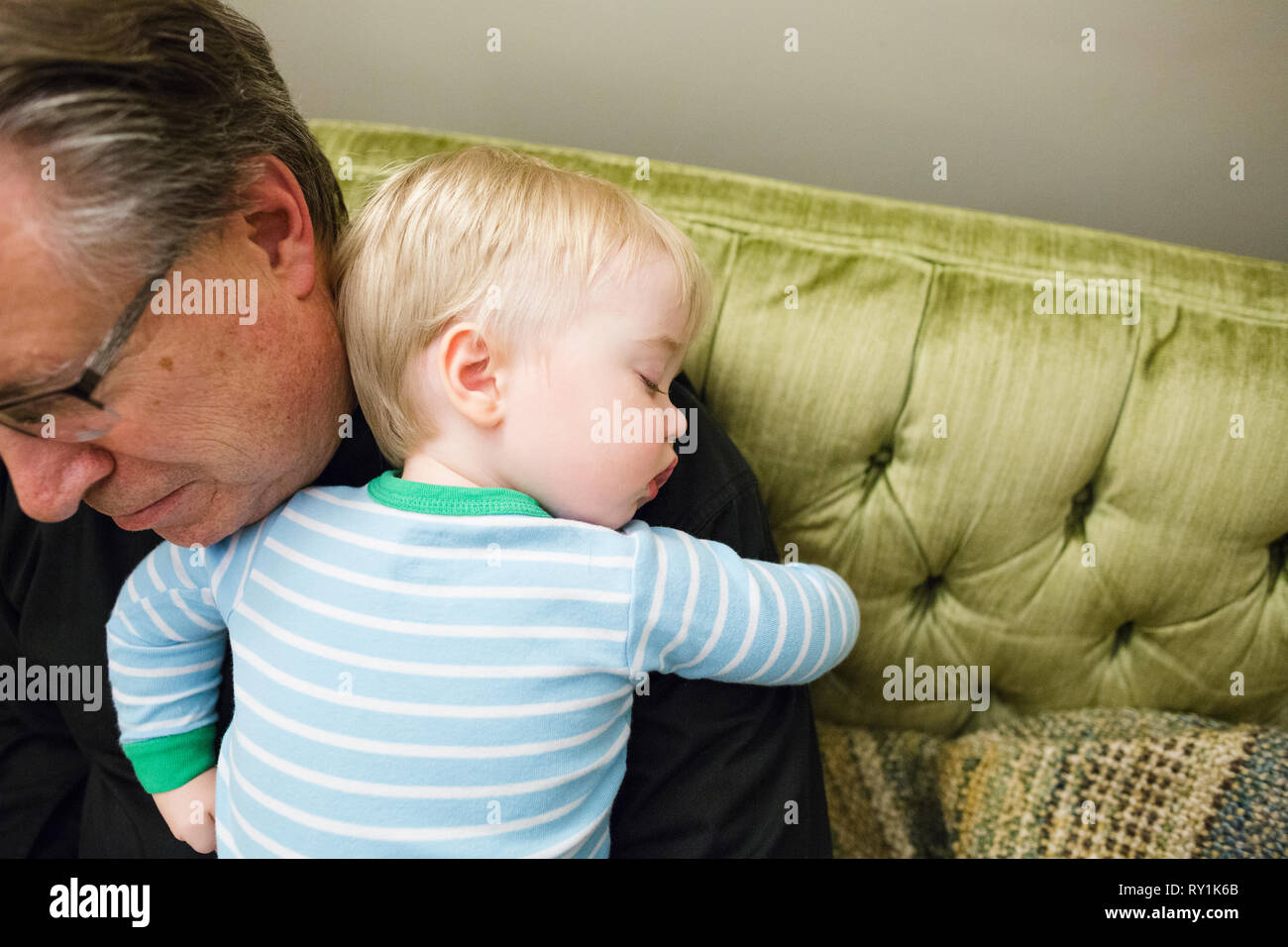 Portrait de grand-père exerçant son mignon petit-fils dormir sur l'épaule à la maison Banque D'Images