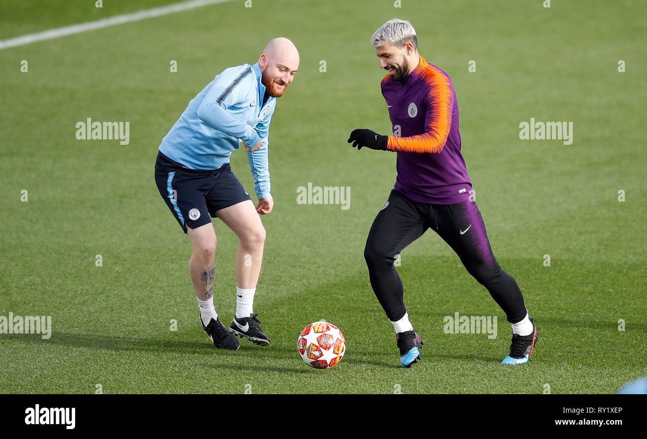 La Manchester City Sergio Aguero tente de dribbler le ballon au-delà d'un membre du personnel de la ville de Manchester au cours de la session de formation à l'Académie de football de la ville, Manchester. Banque D'Images