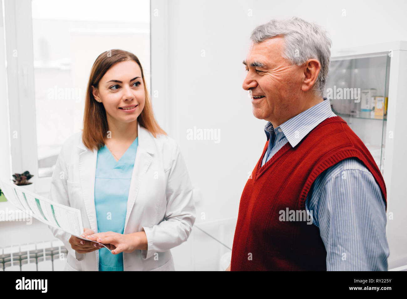 Doctor with senior patient dossier médical médical à prix Banque D'Images Doctor with senior patient dossier médical médical à prix Banque D'Images