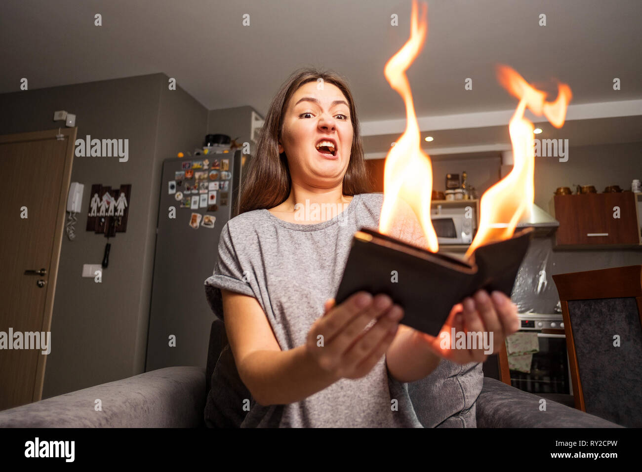 Jeune femme tenant un portefeuille, wallet en feu, surpris fille, concept  magique focus, le portefeuille est un feu brûlant Photo Stock - Alamy