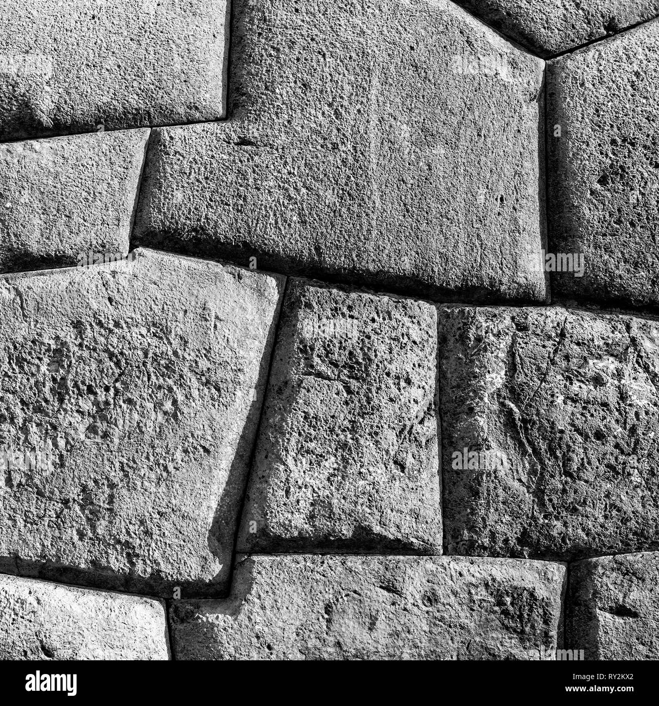 Square photographie en noir et blanc d'un mur Inca dans les ruines archéologiques de Sacsayhuaman à Cusco, Pérou. Banque D'Images