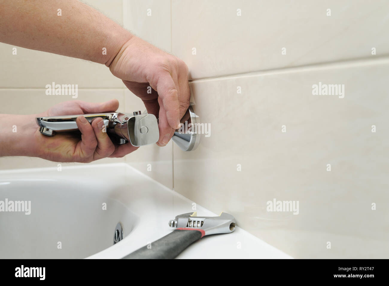 L'installation de robinet avec thermostat. L'homme a les mains robinet baignoire fixation en place. Banque D'Images