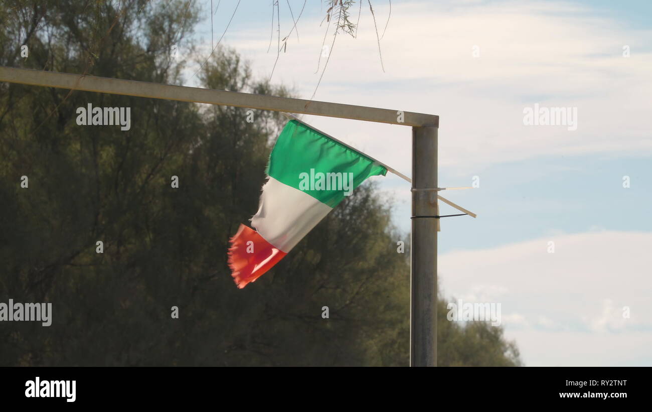 Le drapeau rouge et blanc vert de l'Italie en agitant à l'est de la perche dans la ville sur une journée ensoleillée Banque D'Images