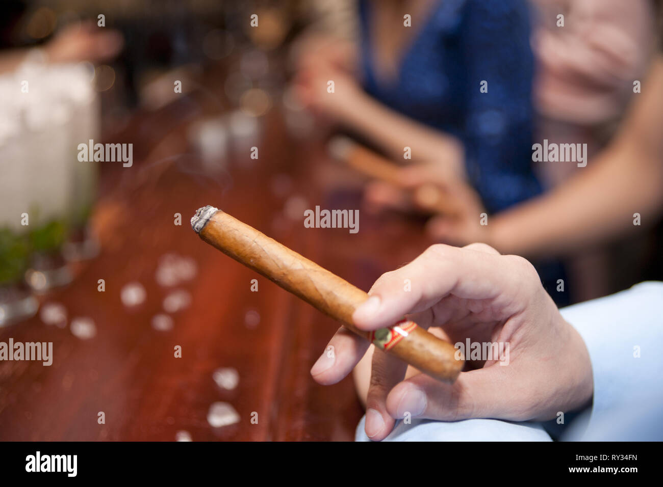 Homme qui fume cigare au comptoir du bar, l'accent peu profondes Banque D'Images