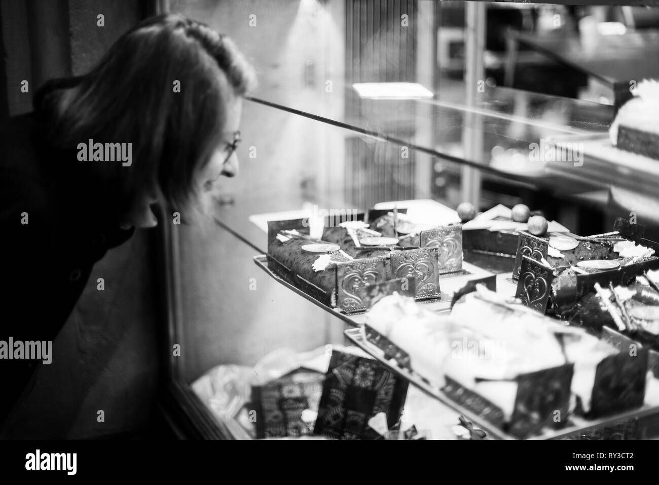 Achat femme bonbons par la pâtisserie boulangerie vitrine en français ville pendant les vacances d'hiver noël Banque D'Images