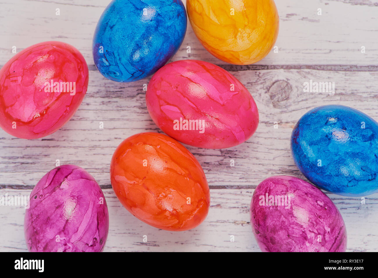 Vue de dessus sur œufs de Pâques colorés sur une surface en bois blanc, couleur macro photo avec copie espace Banque D'Images