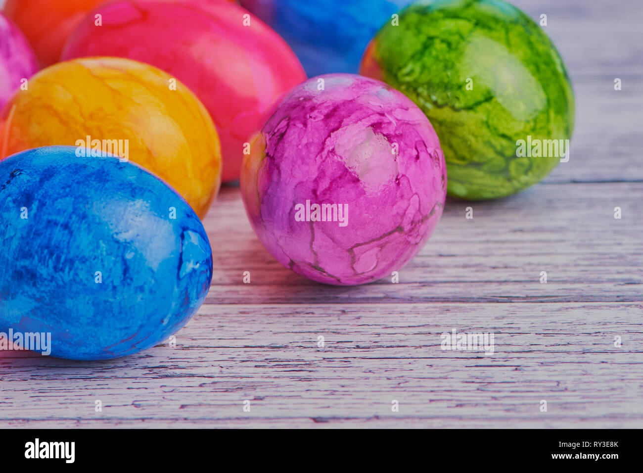 Œufs de Pâques colorés sur une surface en bois blanc, couleur macro photo avec copie espace Banque D'Images