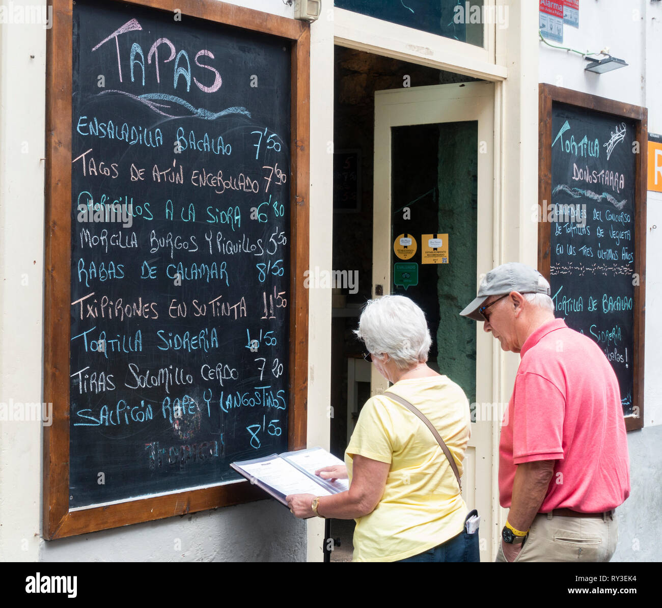 Mature Couple reading menu bar à tapas à Vegueta, Las Palmas, Gran Canaria, Îles Canaries, Espagne. Banque D'Images