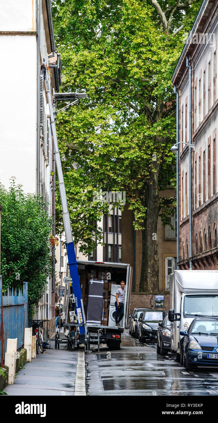 Strasbourg, France - Sep 12, 2017 : les jeunes hommes en attente de l'ascenseur hydraulique de la rampe à livrer un autre paquet au cours de la réinstallation d'accueil Banque D'Images