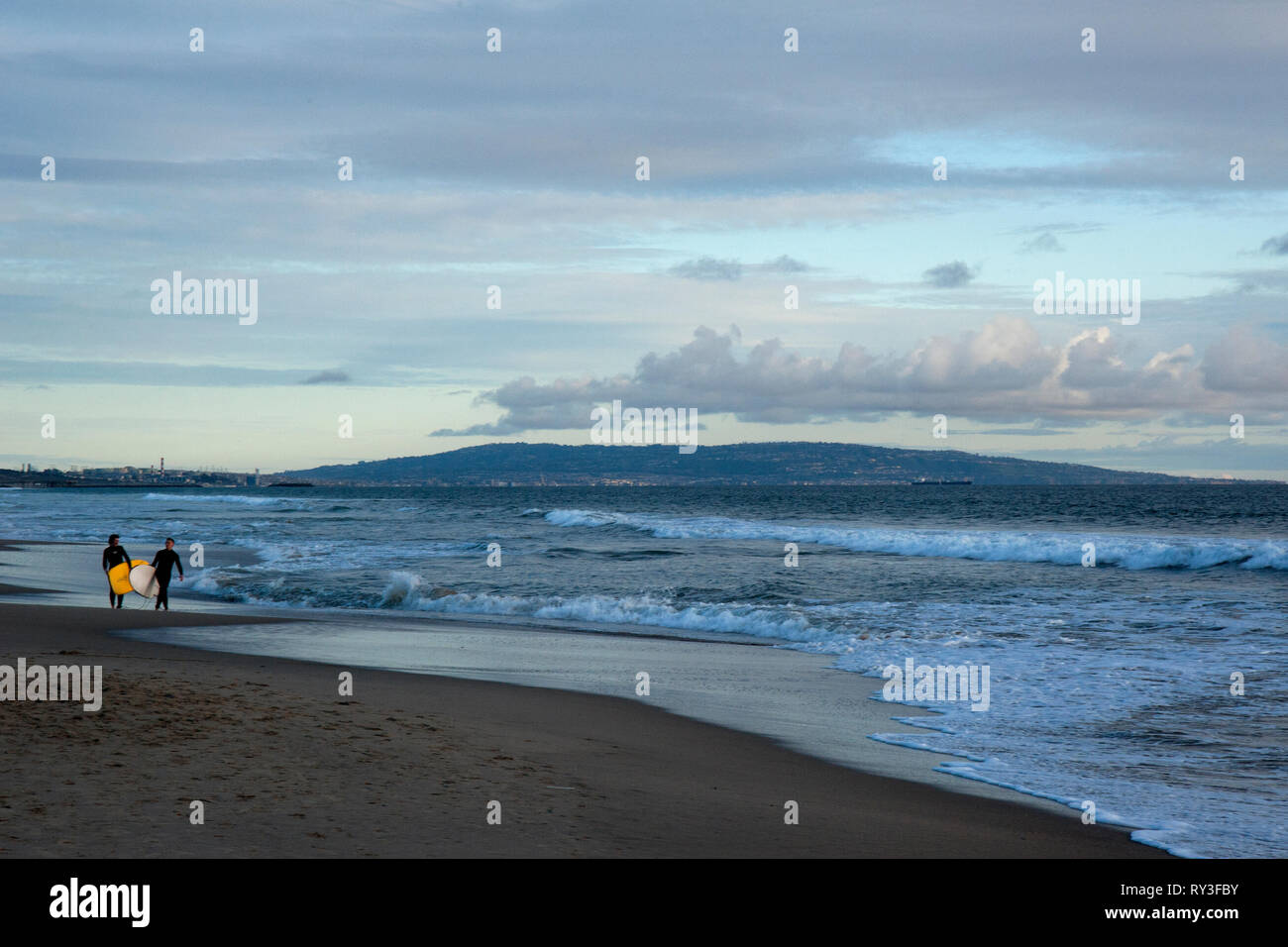 Les surfeurs à la plage de Santa Monica avec la péninsule de Palos Verdes en arrière-plan. à Los Angeles, CA Banque D'Images