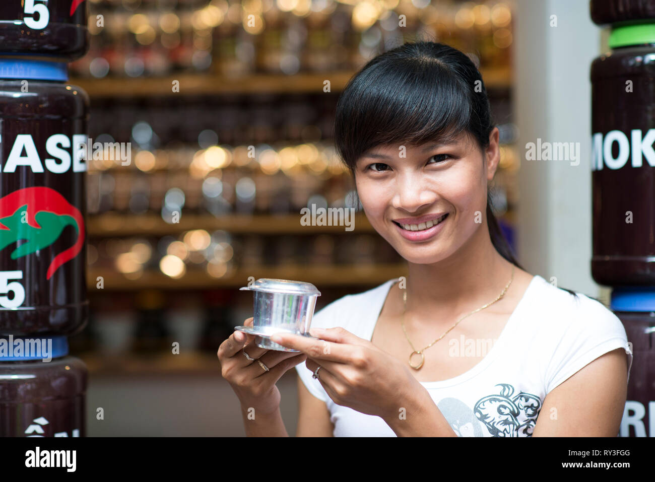 Une femme asiatique souriant avec un café vietnamien - lait chaud Café avec lait condensé au Vietnam style. Boisson traditionnelle vietnamienne Banque D'Images