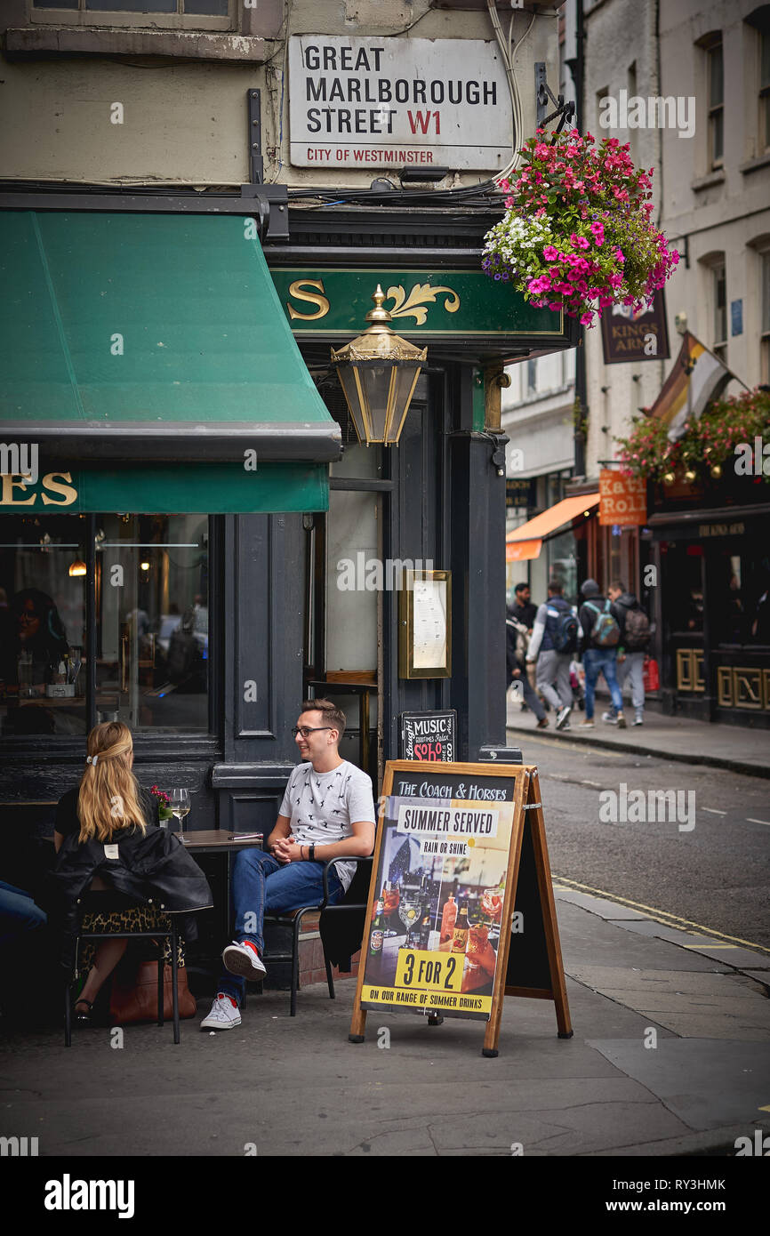 Londres, UK - août 2018. Les jeunes ayant des boissons à l'extérieur d'un bar café à Soho, Londres. Banque D'Images