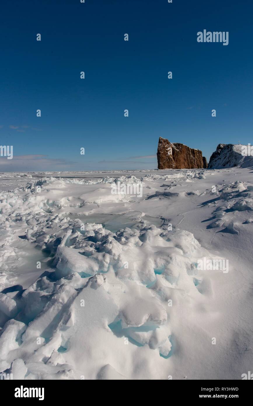 La glace de mer d'hiver avec le majestueux rocher Percé à l'arrière-plan. Banque D'Images