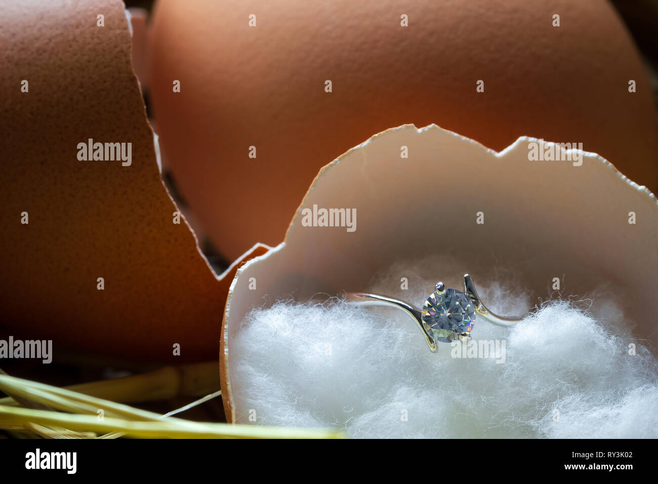 Bague diamant faux dans la coquille de l'oeuf cassé sur l'ovaire avec lumière du matin. Concept de la naissance ou de commencer une vie de couple. Banque D'Images