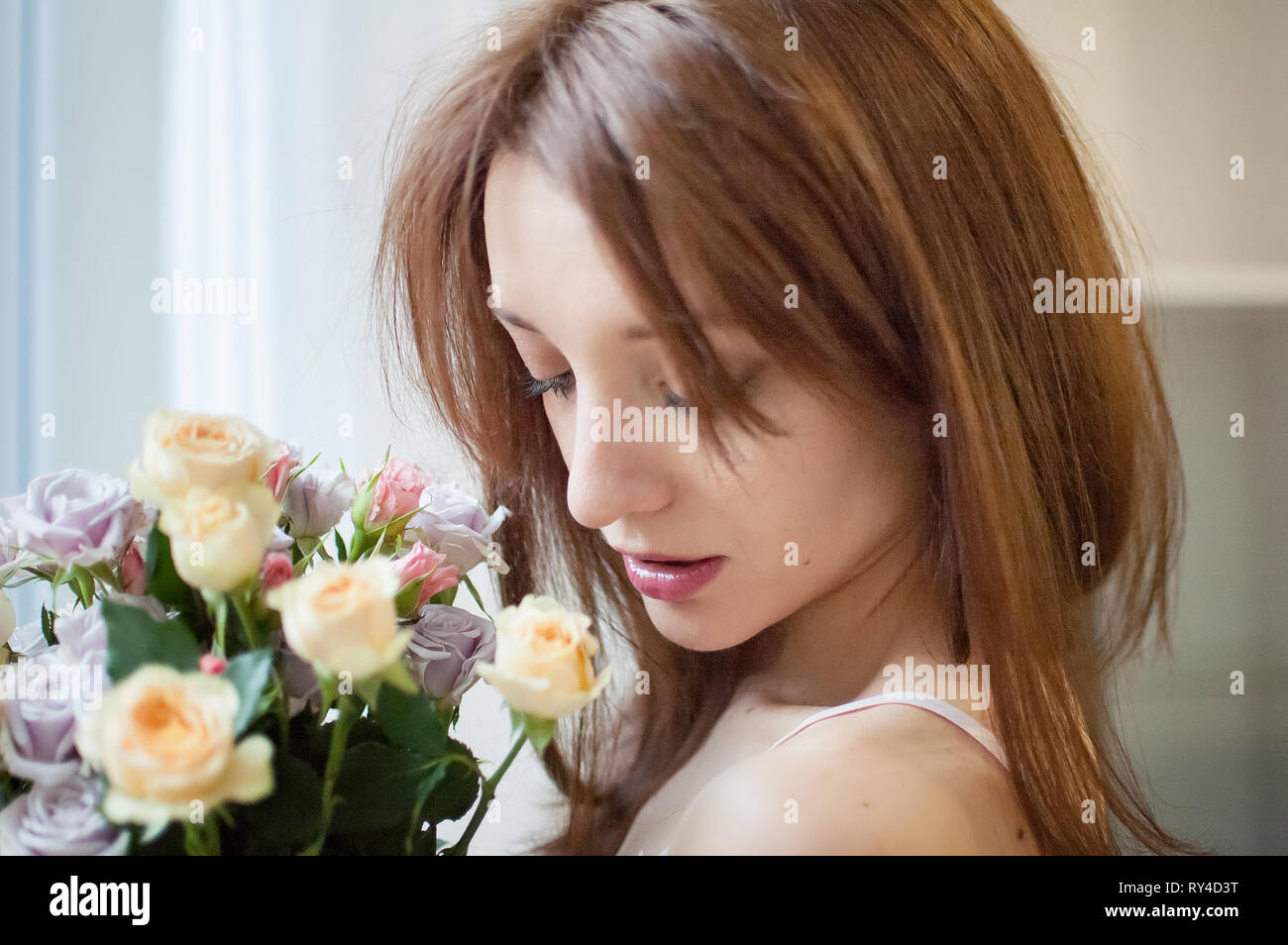 Close up of young female teen avec des fleurs près de la fenêtre à la maison Banque D'Images