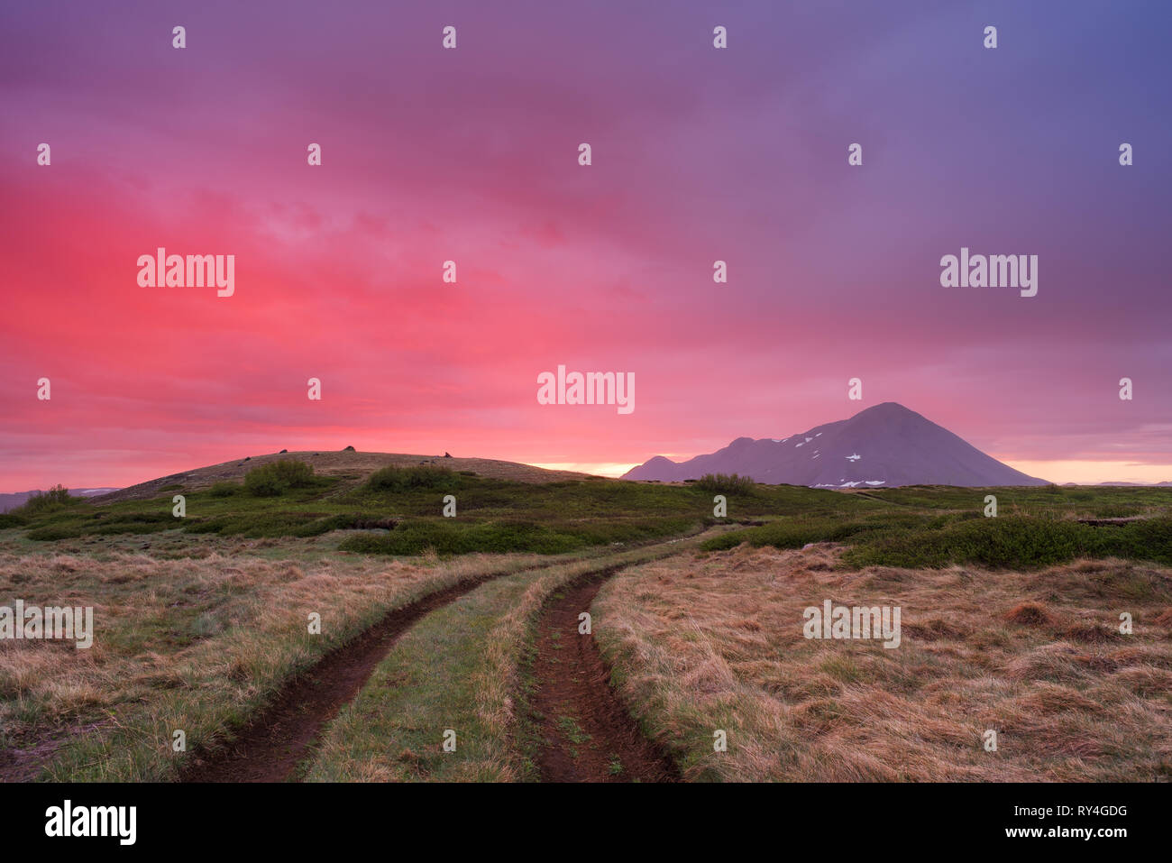 Soleil de minuit en Islande. Belle fantastique à l'aube. Route de terre sur les collines de la montagne. Près du village de Reykjahlid Banque D'Images