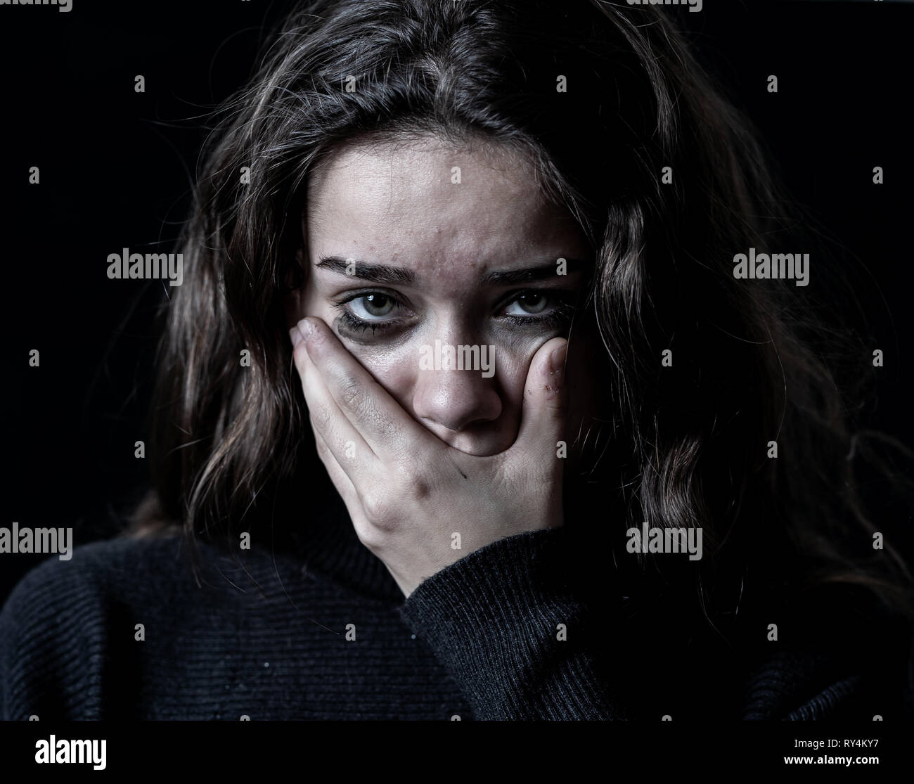 Closeup portrait dramatique de jeunes peur, déprimé girl crying seul, désespoir qui souffrent de harcèlement ou de violence domestique. Enfant d'arrêt ab Banque D'Images