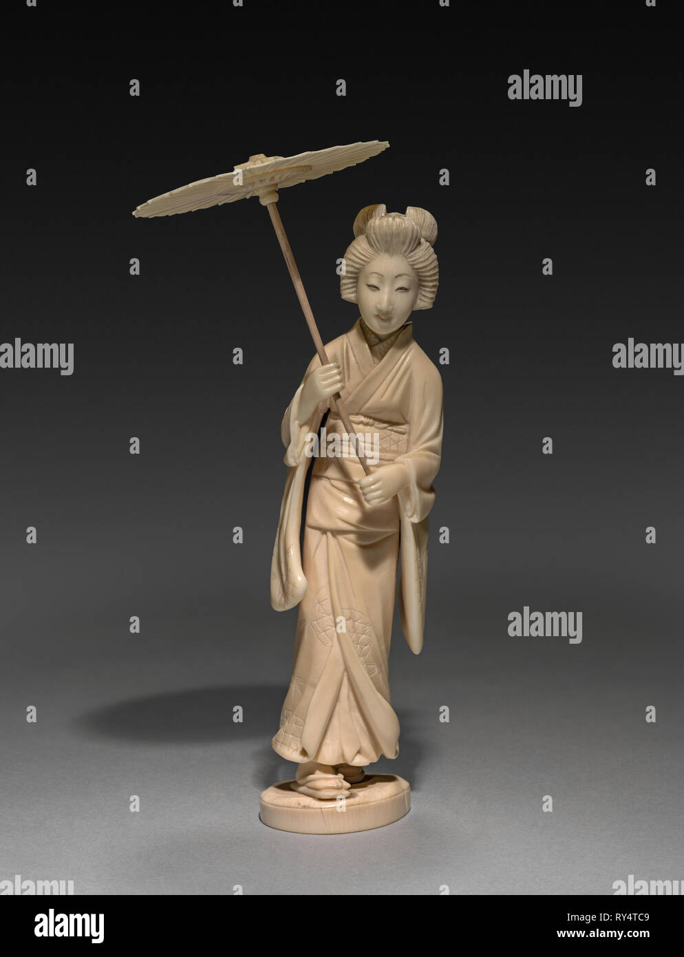 Femme portant un parasol, fin des années 1800- début des années 1900. Le Japon de la fin du xixe- début du xxe siècle. L'ivoire ; total : 14,9 cm (5 7/8 po Banque D'Images
